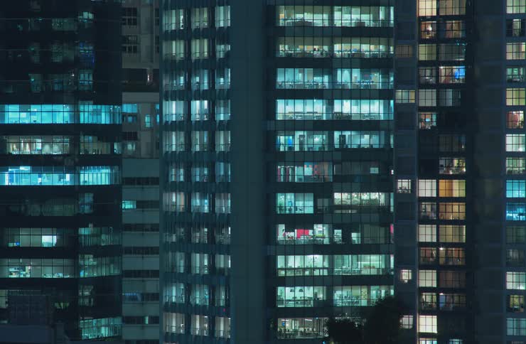Lights illuminate the windows of buildings in the metropolitan city and then turn off