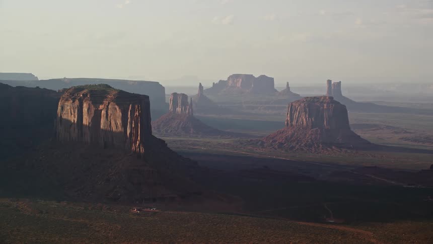 The sun shining across the desert and the butte tops in monument valley