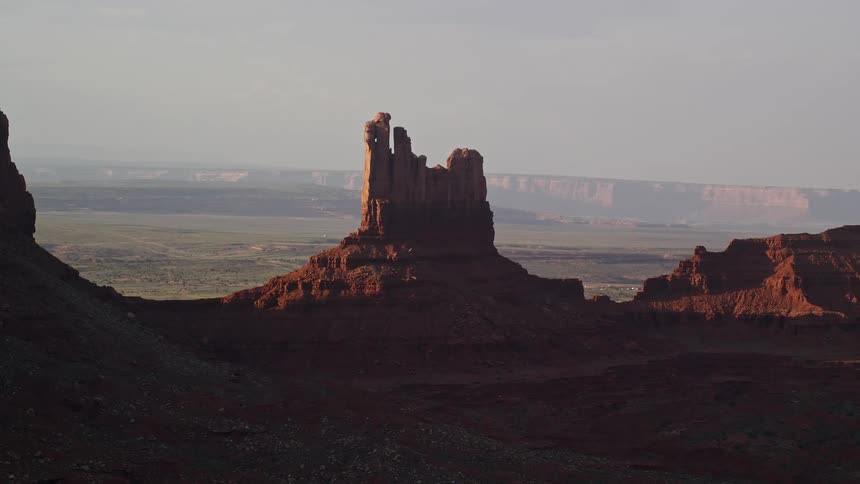 Red rock formation and mountain plateaus on horizon