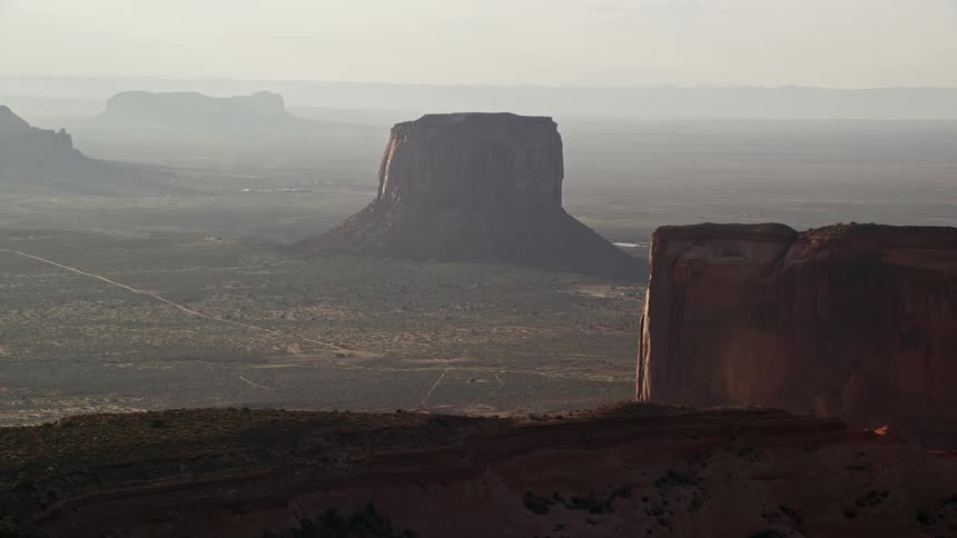 A desert region with badlands and rocky formations with a dirt road