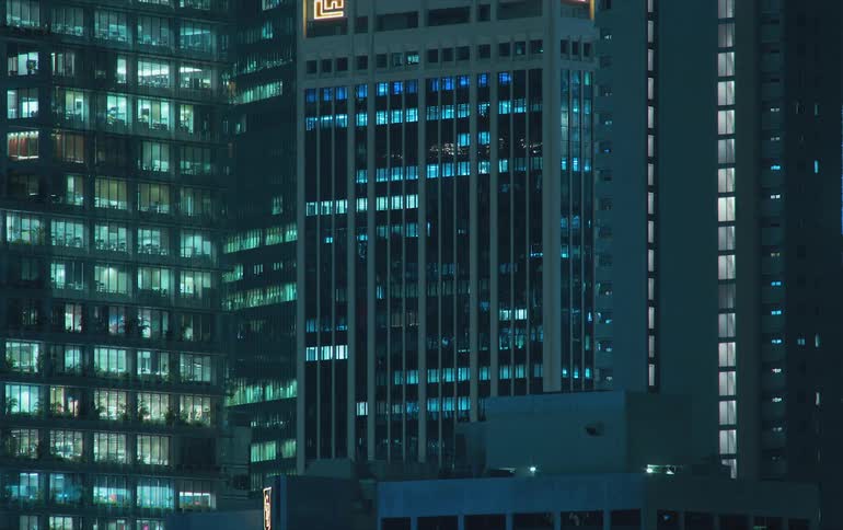 View of buildings with their interior lights gradually dimming the turn off throughout the night