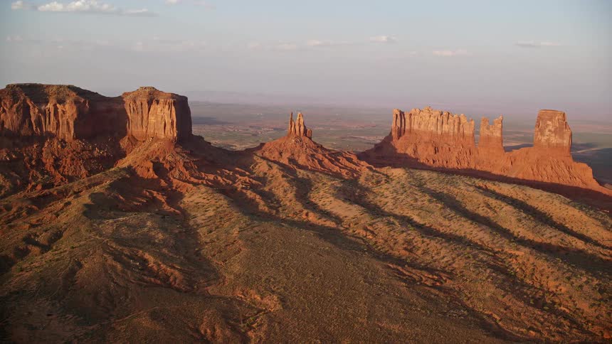 Aerial of butte formations in the desert on a bright sunny day with ridges and valleys on the landscape
