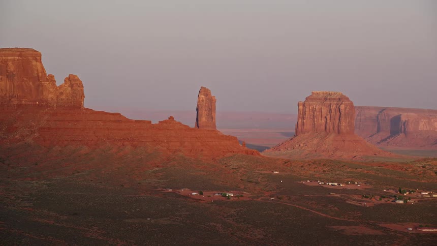 Aerial of butte formations in the desert with a rural village built on the hillsides