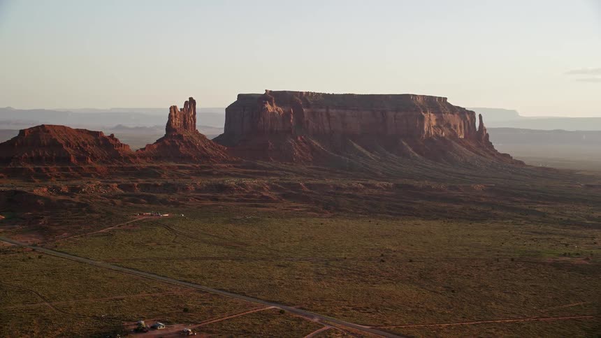 Aerial of a mesa mountain with a flat valley with grass covering it in the desert