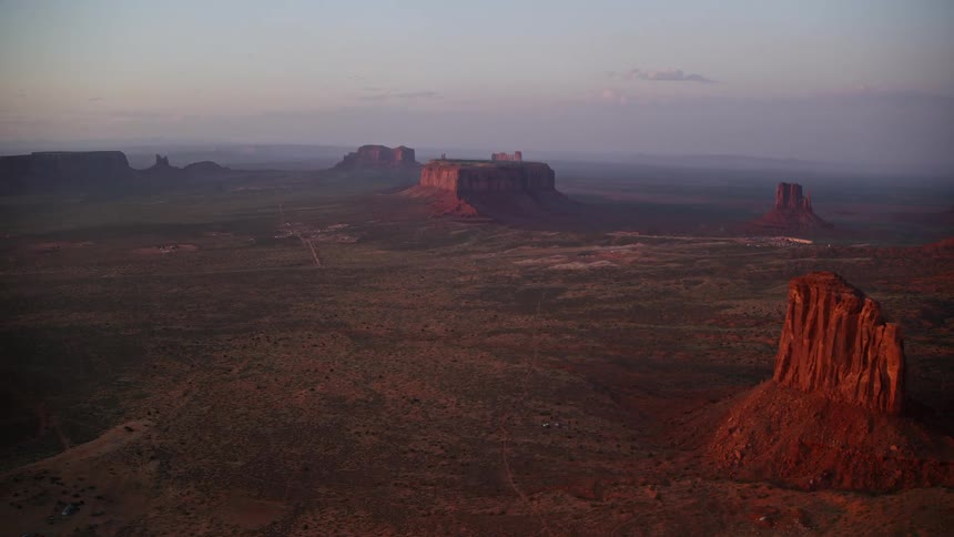 Aerial landscape shot of rock formation in an area with canyons and mountains during day time