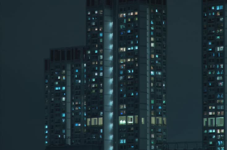 High buildings have apartment lights being turned off as the night goes on