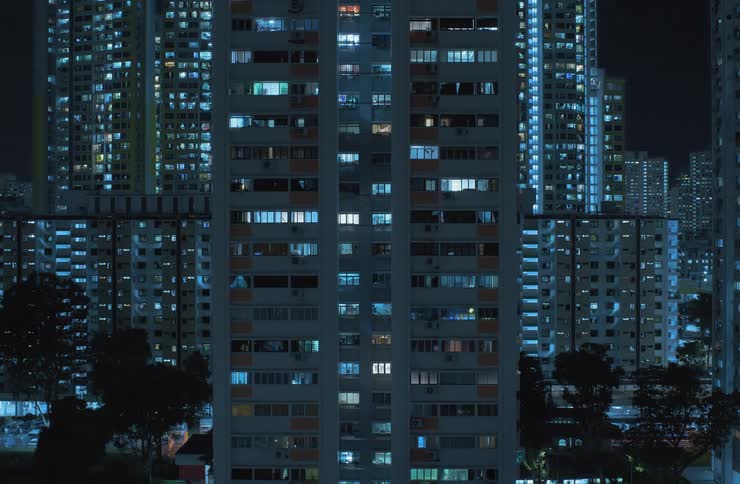 View of residential buildings turning off their lights during the night