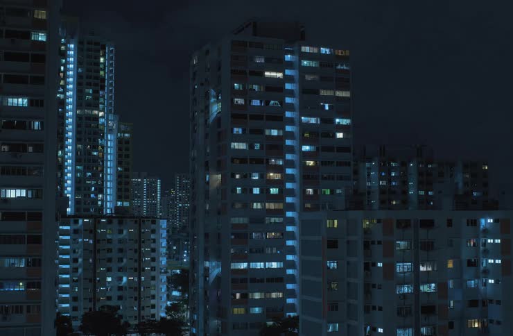 Some tall buildings have apartment lights being turned off as the night goes on