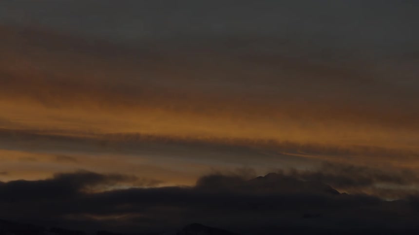 View of the sky with clouds and a golden hue from the sunlight