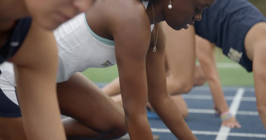Runners preparing to sprint as seen from the starting line