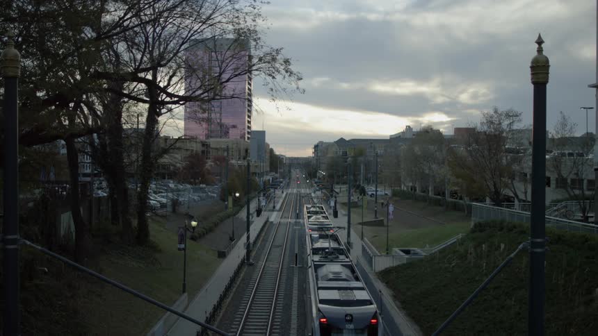 Train moving down the tracks in a city