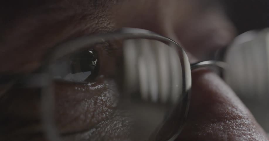 A man is staring forward wearing glasses