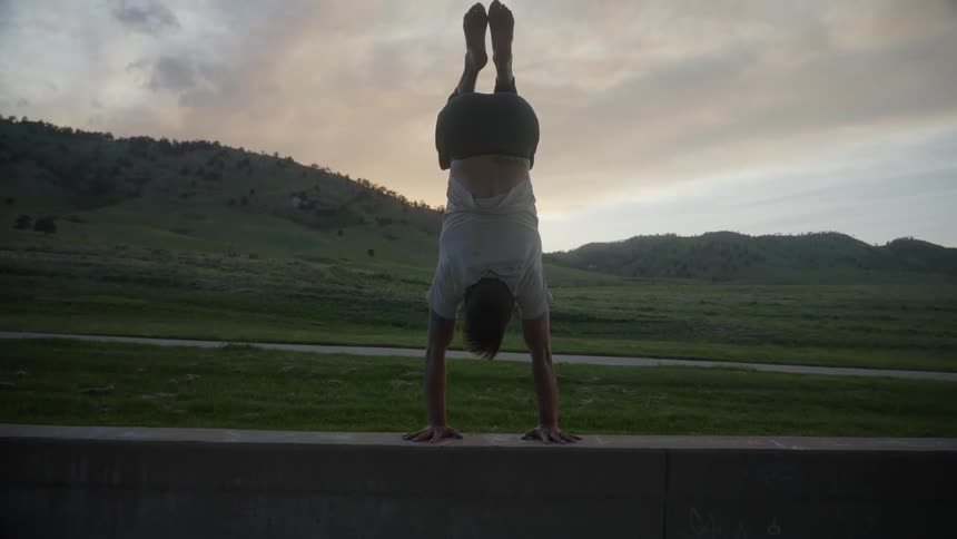 A man plants his hands and slowly lifts himself into a handstand