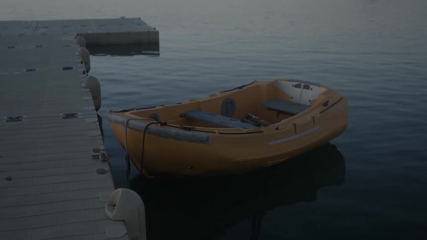 A small boat floats in the water while it is tethered to a dock