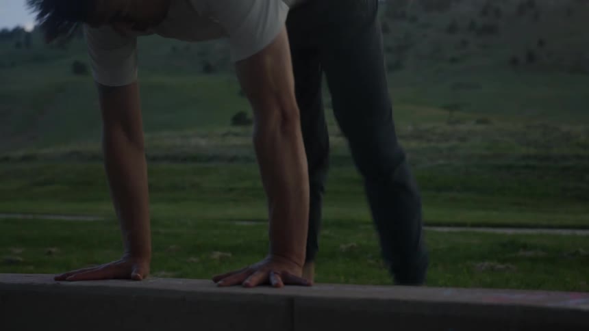 Fit athletic man performs a handstand in the countryside