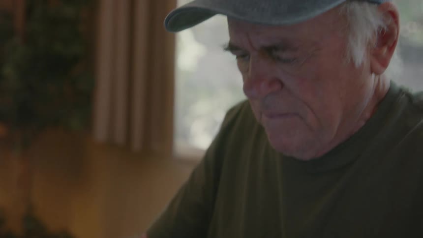 Elderly man working on a laptop at home