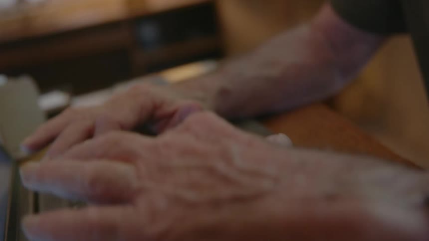 Elderly man working on a laptop at home