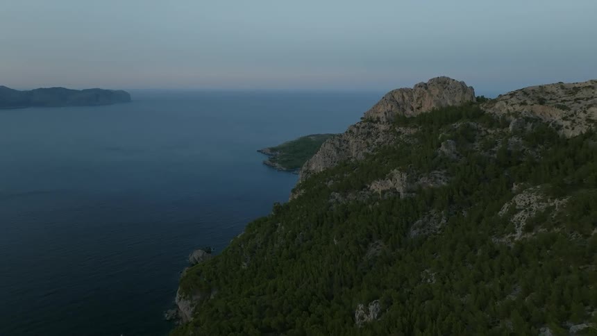 A view of the sea with a coastline mountains and vegetation