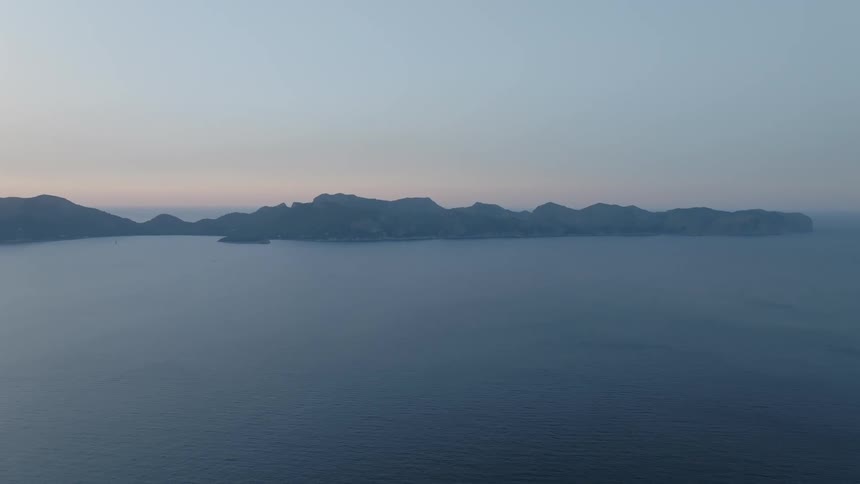Aerial view of mountains on an island in the ocean at evening