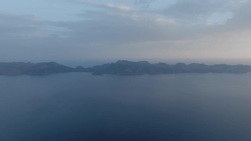 Light fog covers island under a cloudy sky