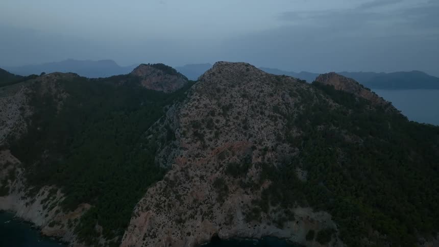 Aerial view of a mountain range surrounded by the sea