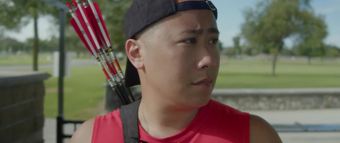 Portrait of a focused young asian man with a bow and arrows on his back