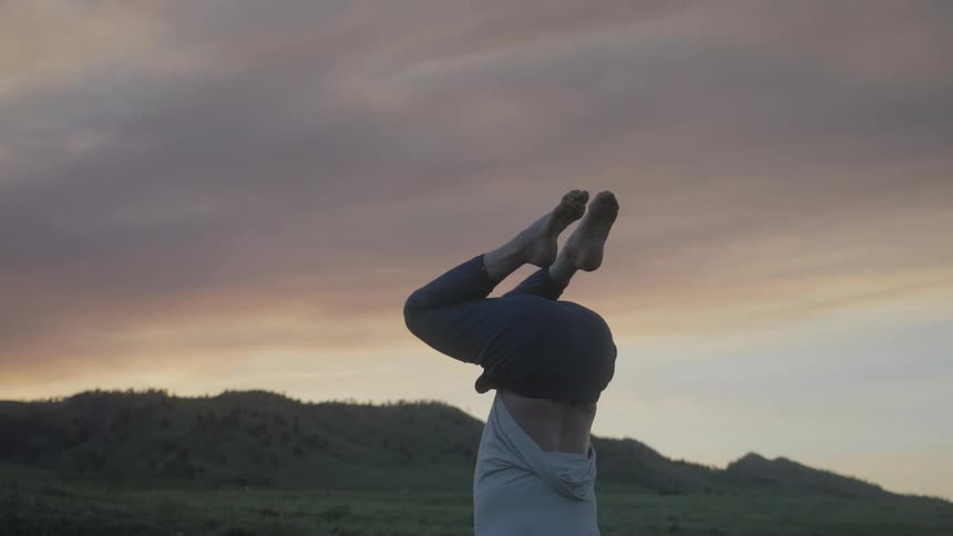 Man stretching his body with his legs up in an outdoor and natural setting