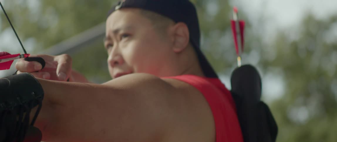 An archer raises his bow and pulls the arrow back as he looks ahead