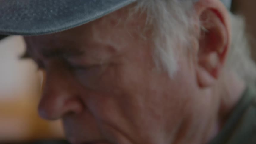An elderly man looking worried after talking on phone