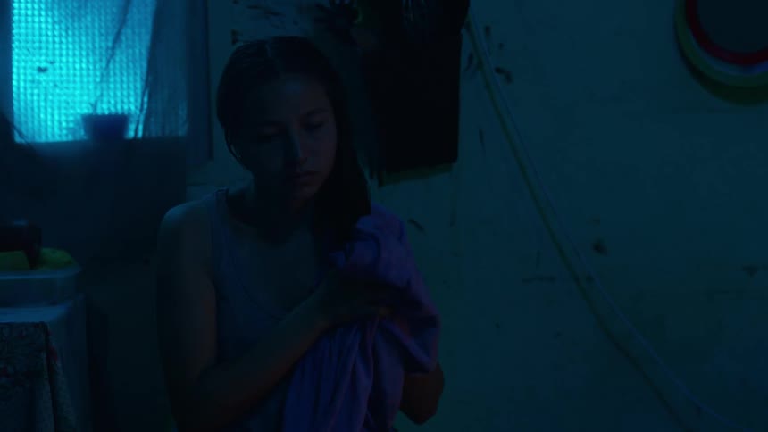 Young lady looking sad while drying her hair sitting in a room