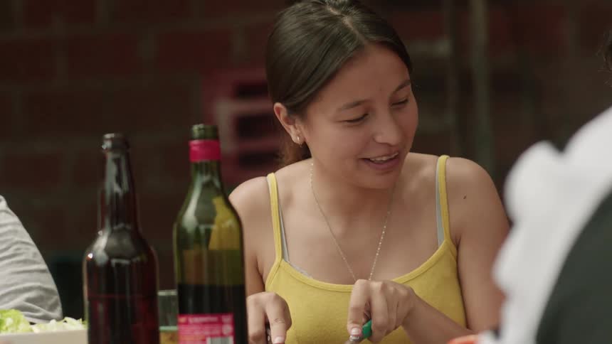 A girl cuts meat on a plate at an outdoor table