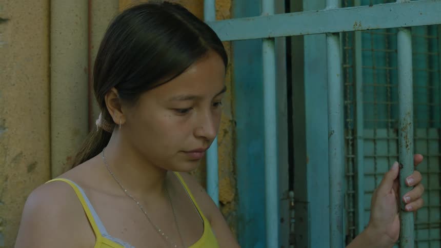 A woman talking to another person holds a railing and then leaves