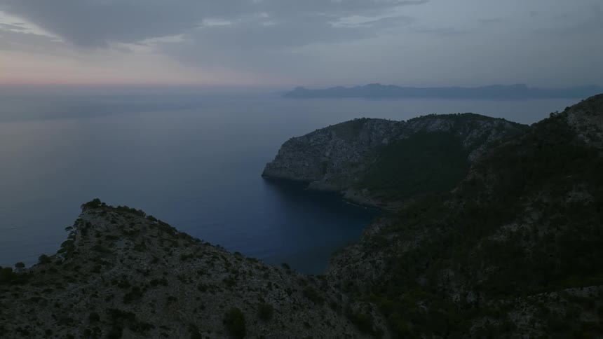 Coastal island skyline with mountains at sunrise