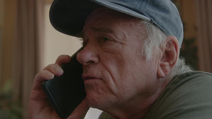 Senior citizen talks on the phone at home