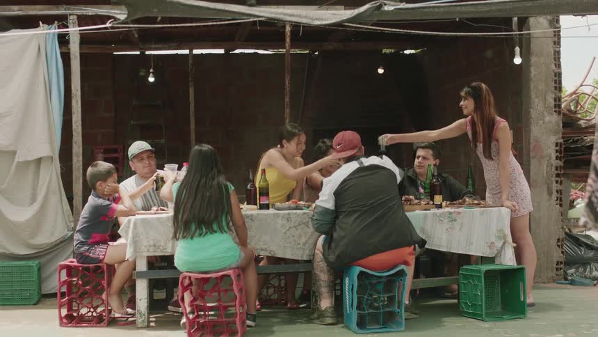 Several people sitting at a table are eating and toasting