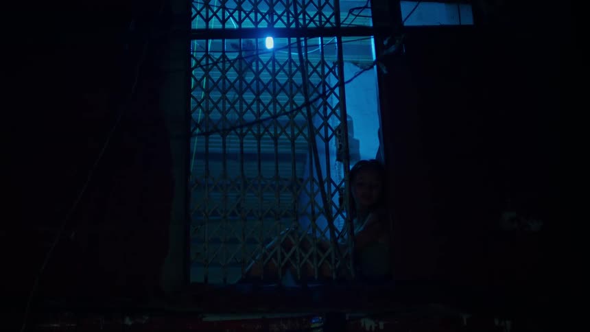 Person sits alone in a room at night