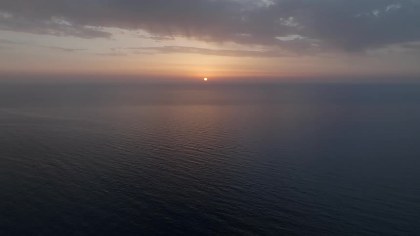 Aerial view of the sea with the dawn breaking on the horizon