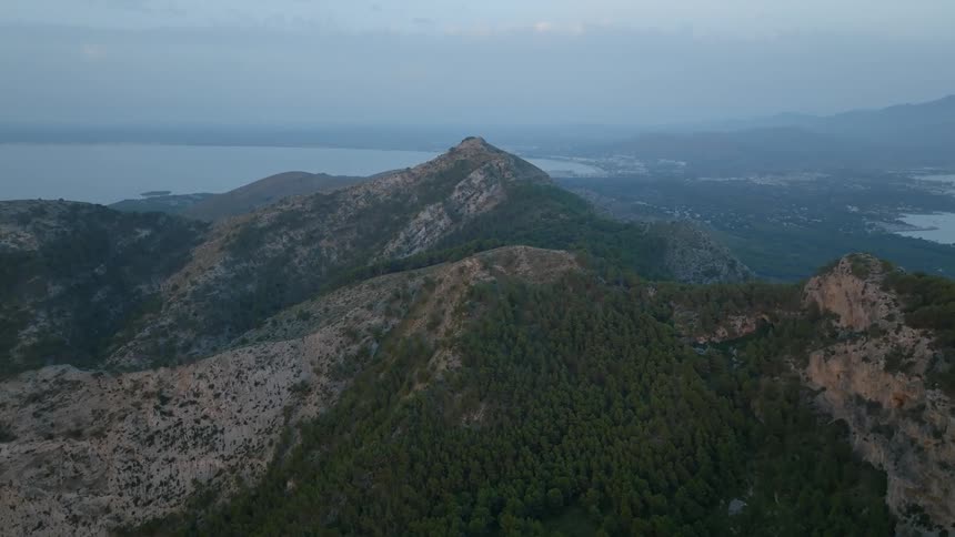 Aerial view of a mountain range with a river in the background