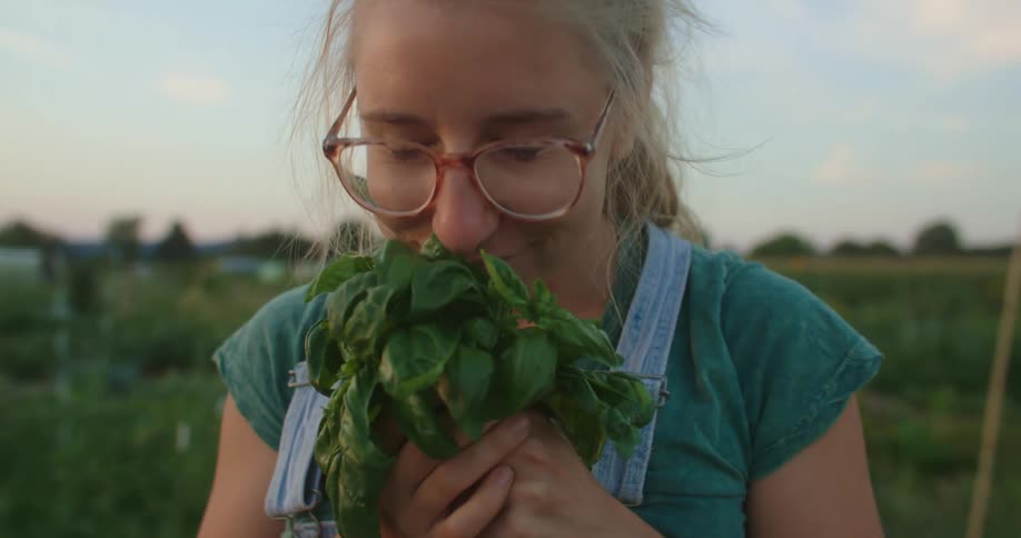 Young lady smells a farm produce and smiled afterwards