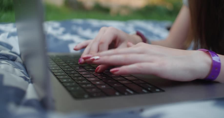 A person typing quickly on a laptop keyboard