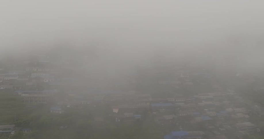 Aerial of a developing nation with houses built close together as fog settles over them