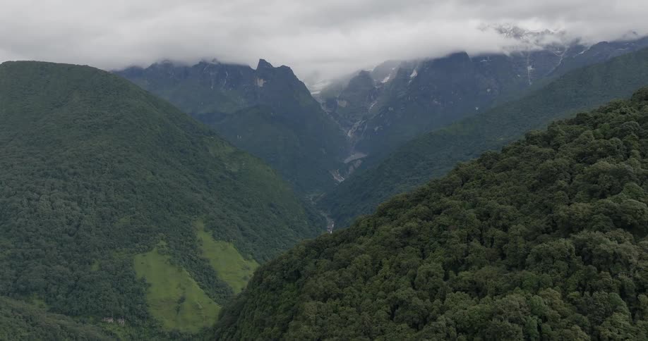Aerial view of forested mountain slope and river on a cloudy day