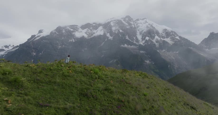 A person walking on top of the mountain during the winter