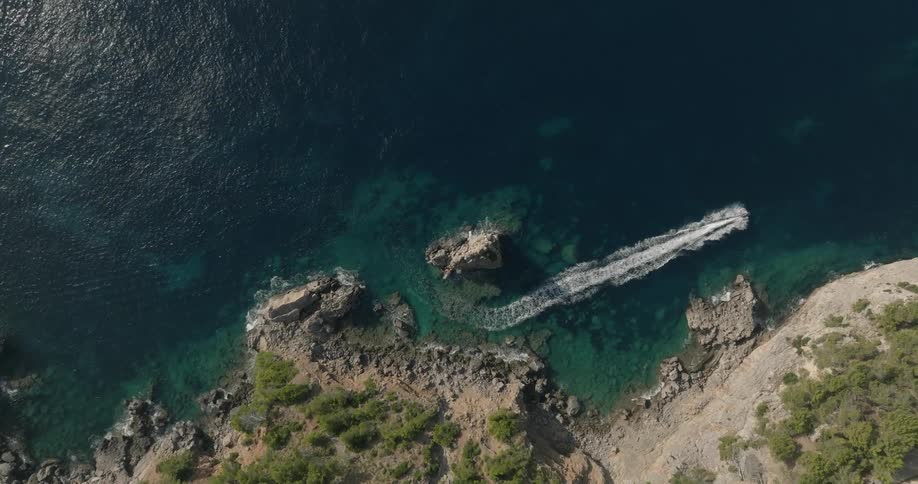 Aerial of a boat sailing near the shoreline of the beach
