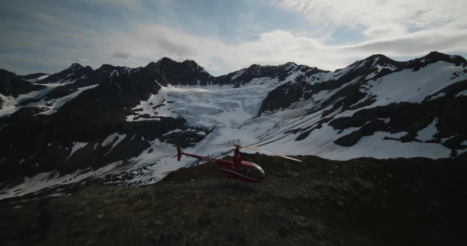 A helicopter is perched on top of the mountain