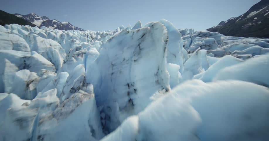 Multiple ice forms near mountains on a sunny day