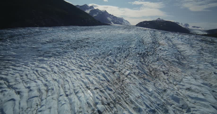 Aerial of landscape with ice and mountains with snow at the peak