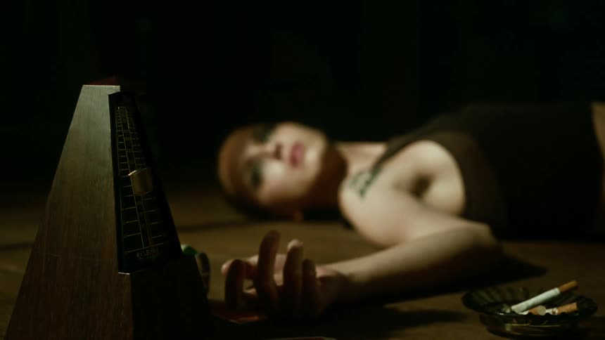 Lady laying on the floor on her back while toying with a device at night