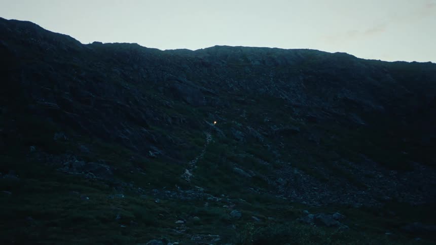 A faint light on a trail in the mountains at morning