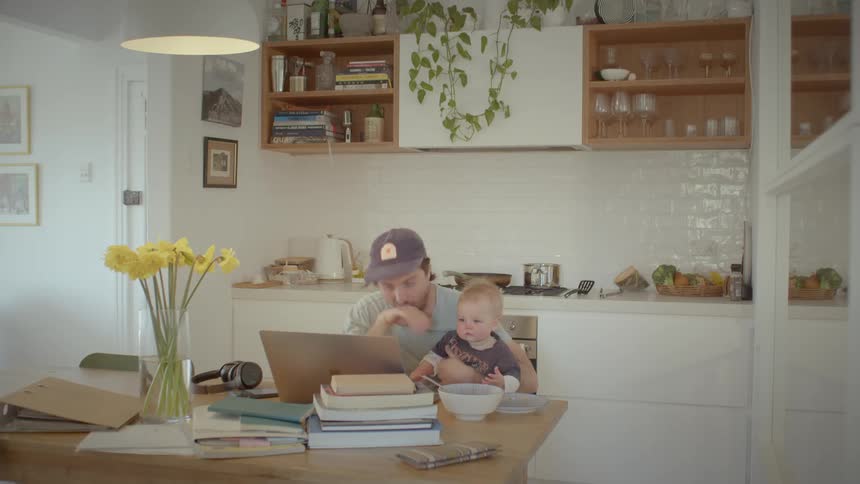 A father and son look at the laptop together